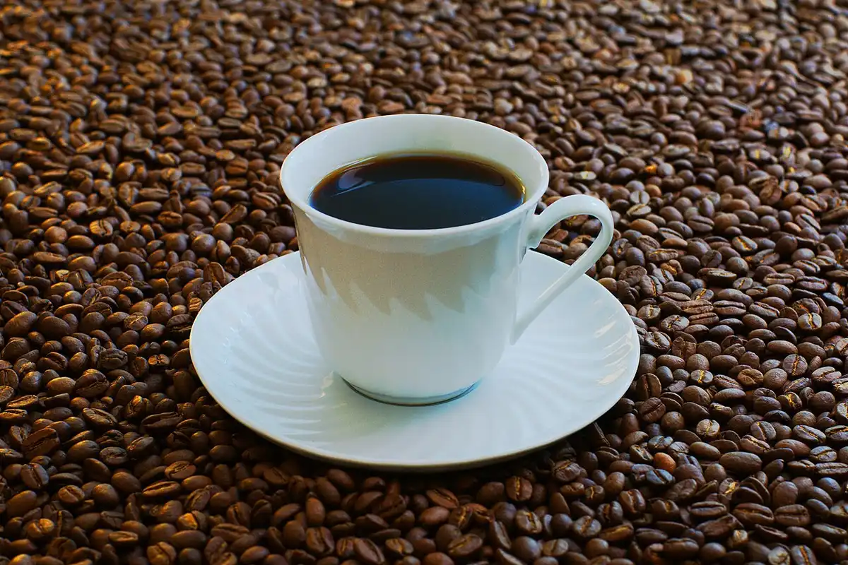 Taza de café vista desde arriba con granos