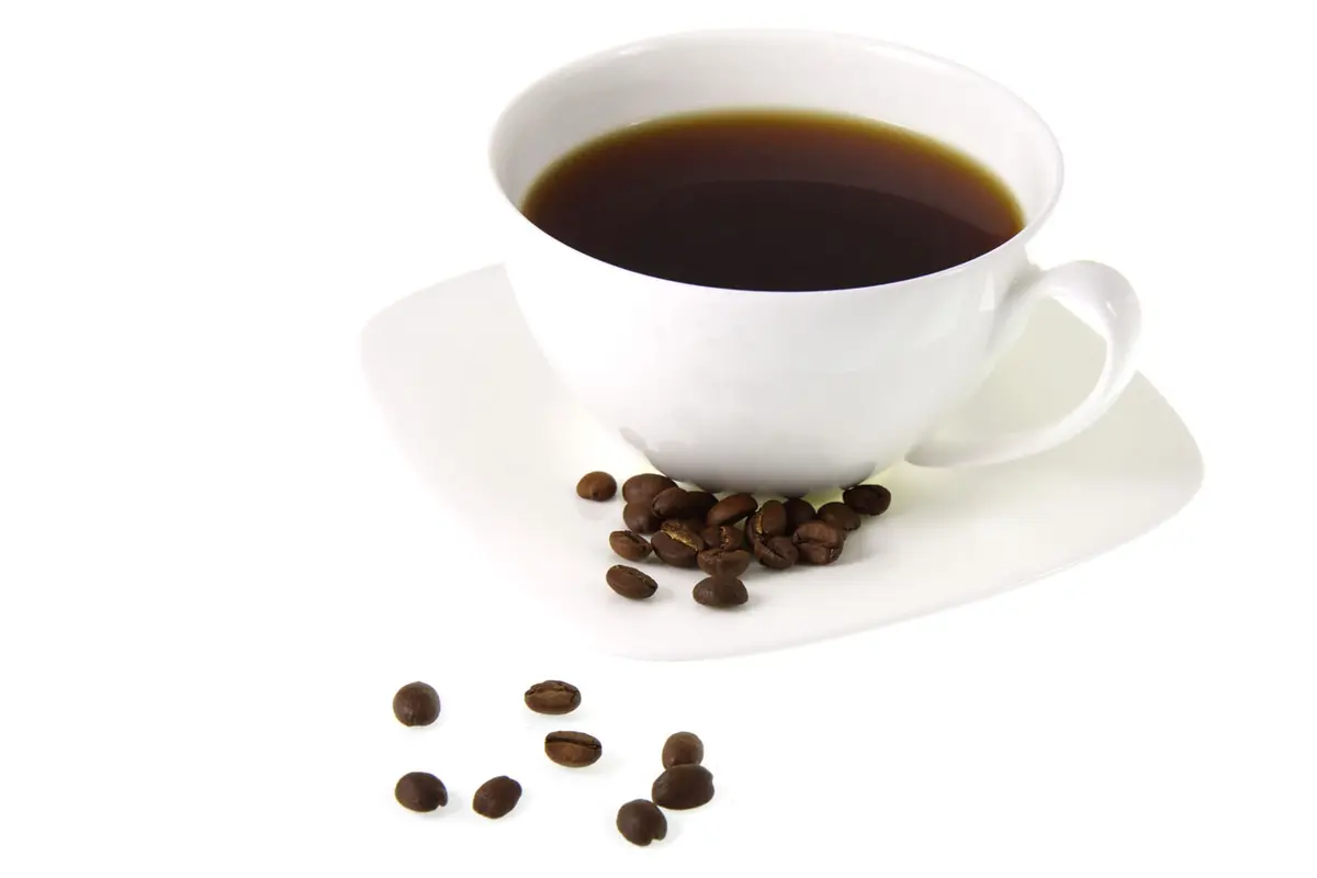 Taza de café con granos sobre fondo blanco
