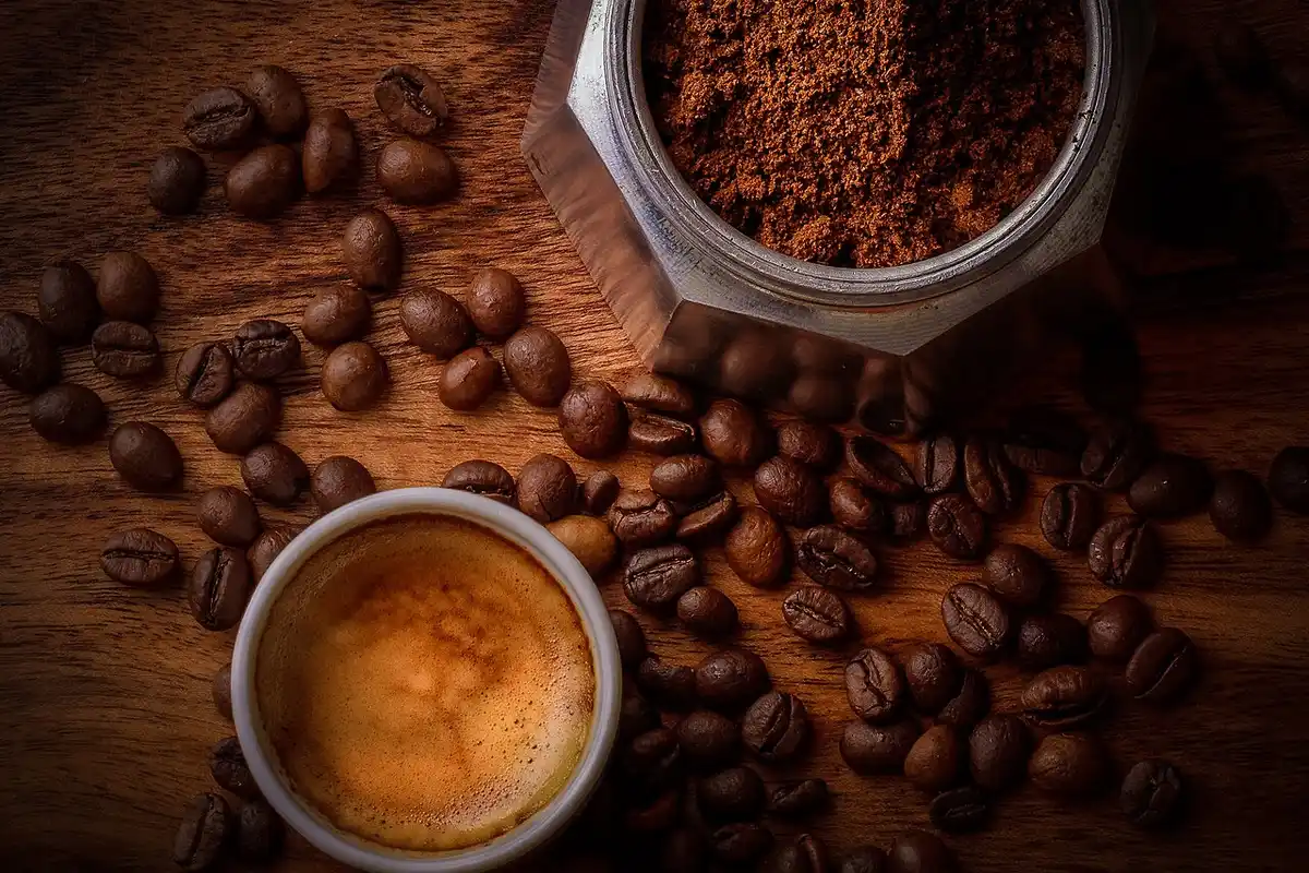 Espresso recién hecho junto a café molido