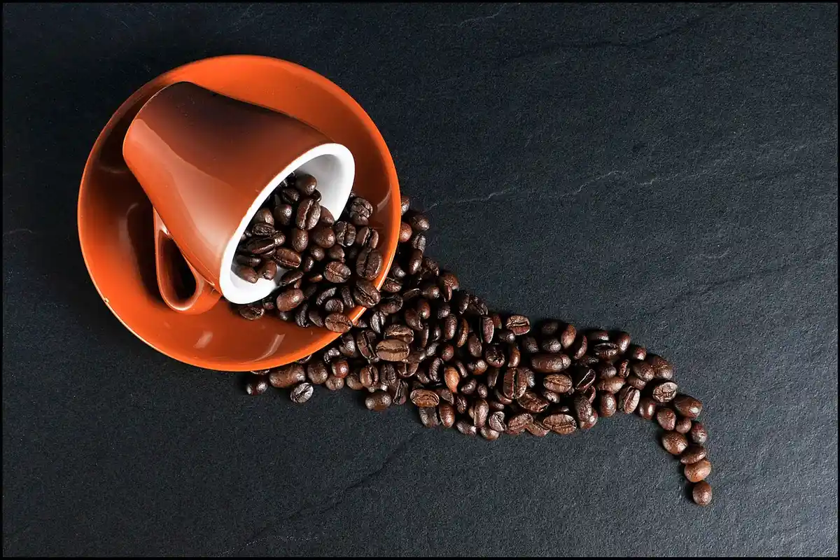Taza volcada con granos de café